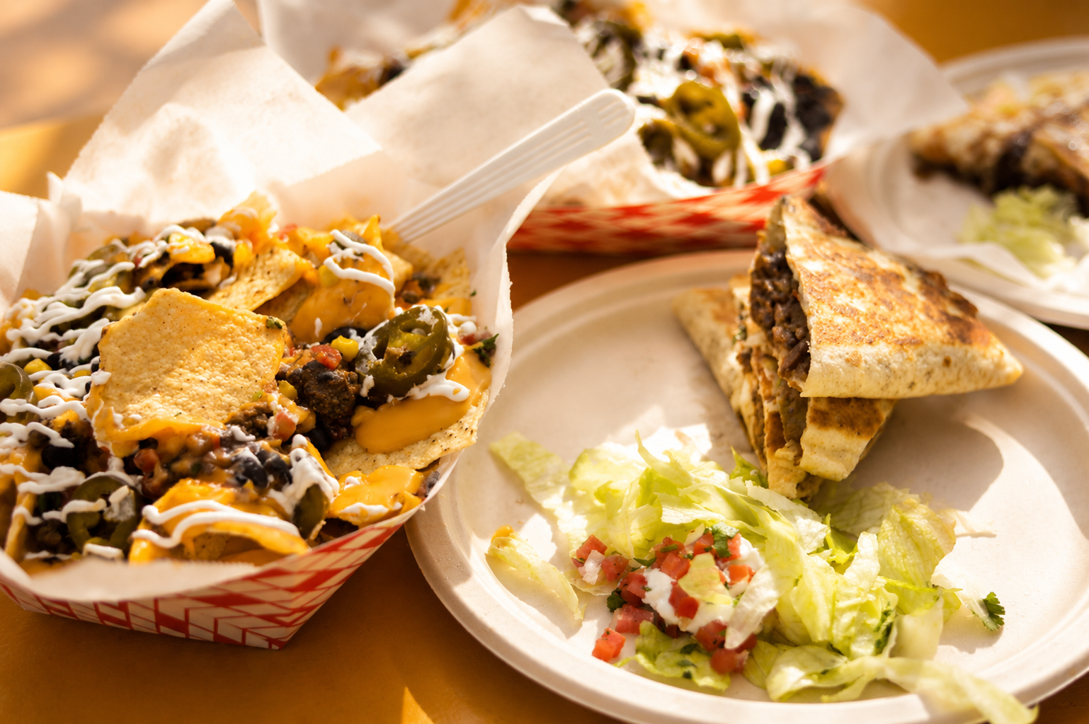Two tacos on a black plate with lime